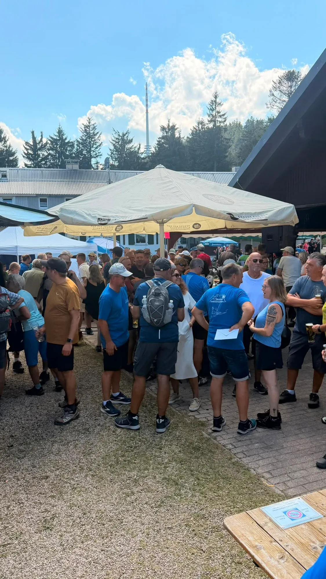 Menschen treffen sich auf dem Platz zwischen Hütte und Festzelten.
