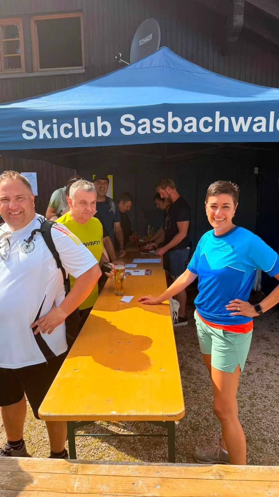 Menschen in blauen Vereinsoberteilen hinter einer Ausgabetheke.