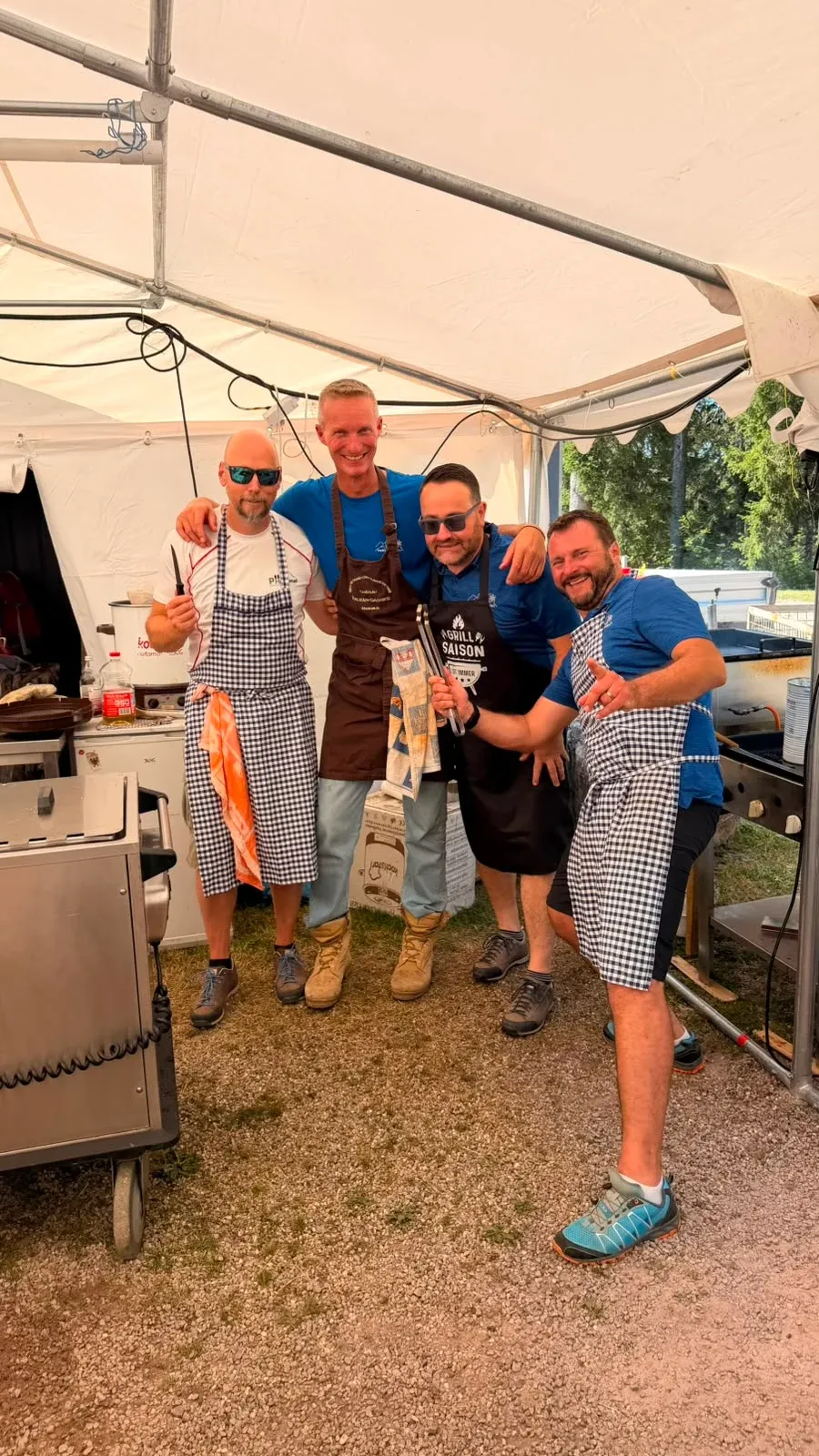 Eine Gruppe steht gemeinsam im Eingangsbereich eines Zeltes.