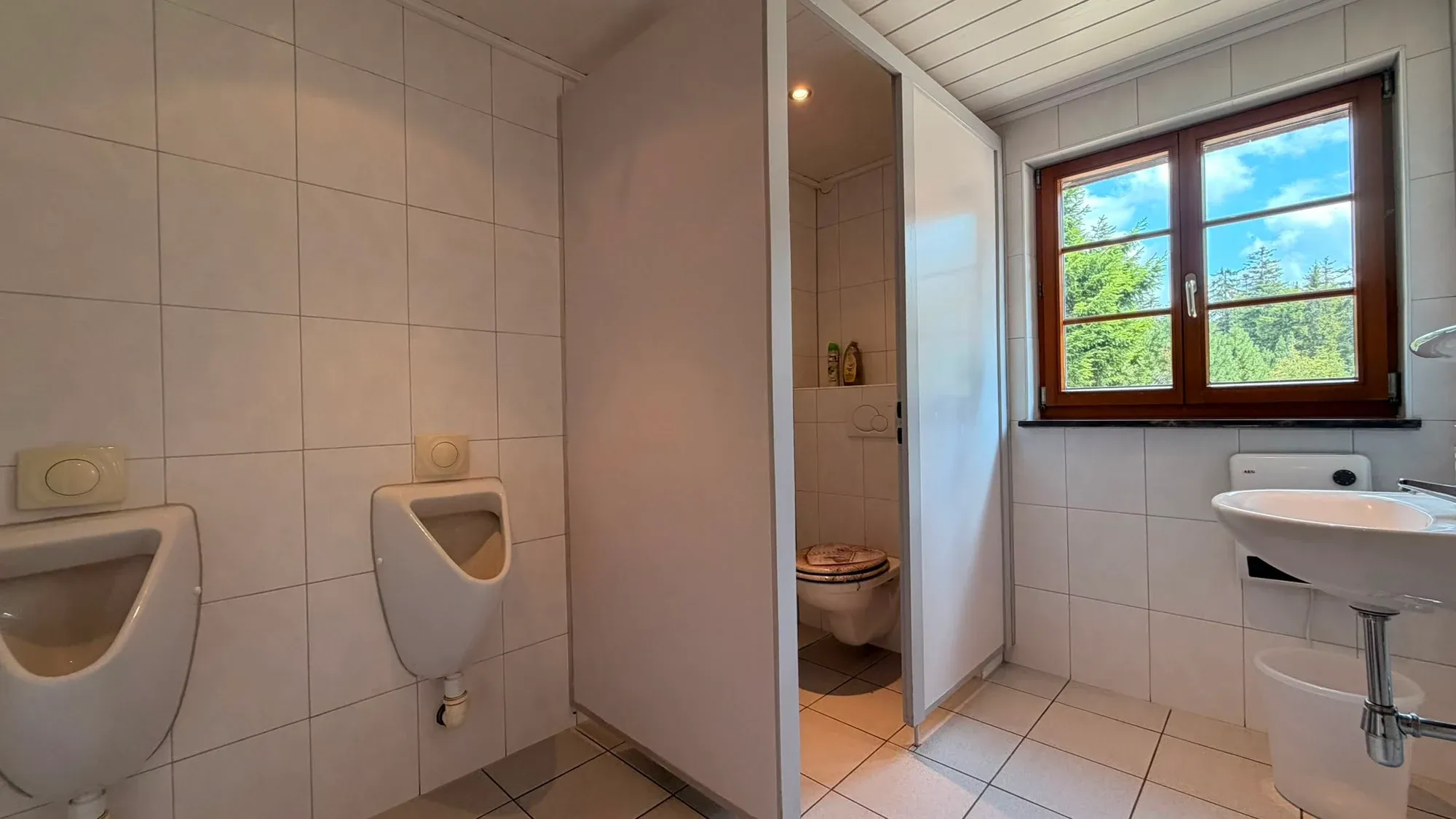 Sanitärraum mit Urinalen und Waschbereich in der Hütte.