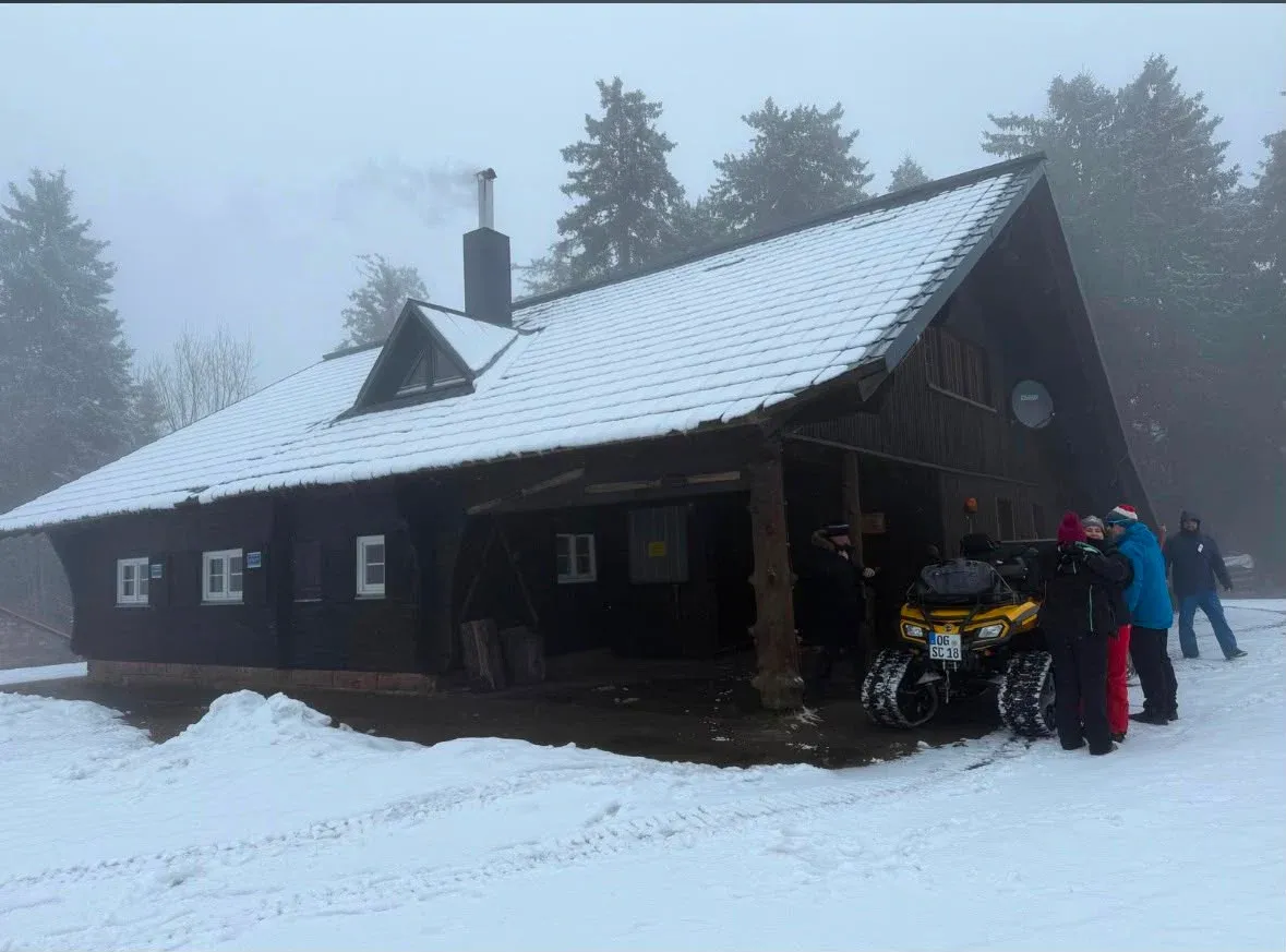 Winterliche Außenansicht der Hütte mit Menschen am Eingang.